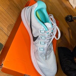 Mostly white Nike running sneakers.